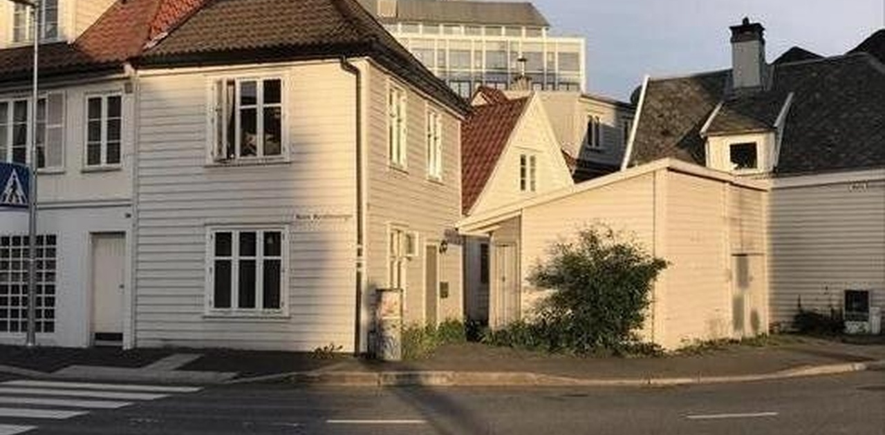 Boligen er det hvite huset med svart tak